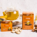 A package of Prince of Peace Energy Tea, a sachet, and the ingredients in front of a glass teapot.