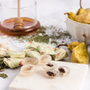 Loquat in Prince of Peace Honey Loquat Candy with some individual wraps, dried pears, and a jar of honey on a white background.