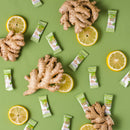 Pieces of Prince of Peace Ginger Chews Plus+, Lemon with lemon slices and ginger on a green background.