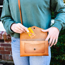 A lady is putting a box of Trumpet Brand Seirogan TOI-A, 36 ct (Sugar Coated) into a totebag.