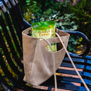 A package of Prince of Peace Ginger Candy (Chews) With Mango in a tote bag on a chair in a garden.