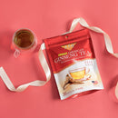 A package of Prince of Peace American Ginseng Instant Tea with a cup of tea and a ribbon on a pink background.