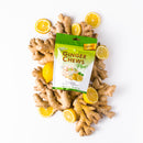 A package of Prince of Peace Ginger Chews Plus+, Lemon, 3oz in front of some gingers and lemons on a white background.
