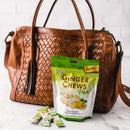A package of Prince of Peace Ginger Chews Plus+, Lemon, 3oz with some pieces in front of a tote bag.