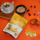 A glass of Prince of Peace Instant Wild American Ginseng Tea with sachets, package, teapot, and red dates on an orange background.