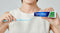 A lady hold a YNBY toothpaste and a tooth brush.