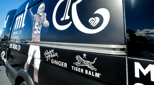Prince of Peace and Tiger Balm logo on a black barber Van.