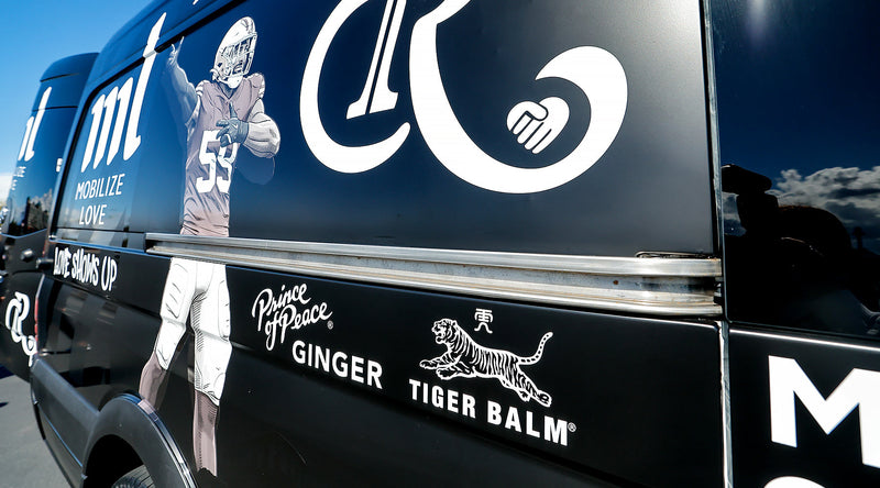 Prince of Peace and Tiger Balm logo on a black barber Van.