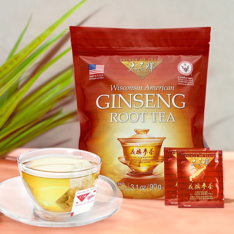A glass of Prince of Peace Wisconsin American Ginseng Root Tea with a package and 2 tea bags on a table.