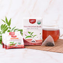 Prince of Peace High Mountain Black Organic Whole Leaf Tea with a tea bag and a cup of tea aside.