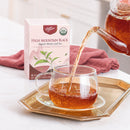 A package of High Mountain Black Tea, a teapot is pouring tea into a glass cup.