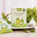 A box of Prince of Peace Green Grape Whole Leaf Tea on a plate with a tea boa package aside in front of the green grape.