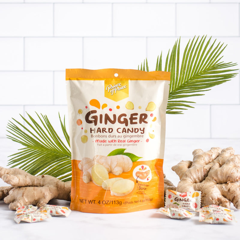 A package of Prince of Peace Ginger Hard Candy with some pieces, and gingers in front of a leaf.