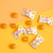 Some pieces of Prince of Peace Ginger Hard Candy with individual wraps on a yellow background.