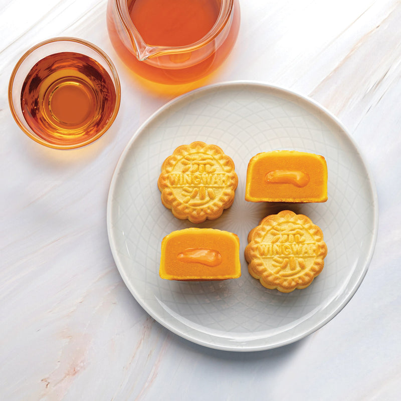 Wing Wah Molten (Lava) Custard Mooncake in a plate with a cup of tea.
