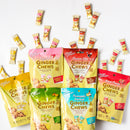 A flat-lay arrangement of Prince of Peace Ginger Chews in multiple flavor bags, with several individual wrapped pieces scattered around on a clean white background.