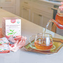 A package of High Mountain Black Tea, a teapot is pouring tea into a glass cup.