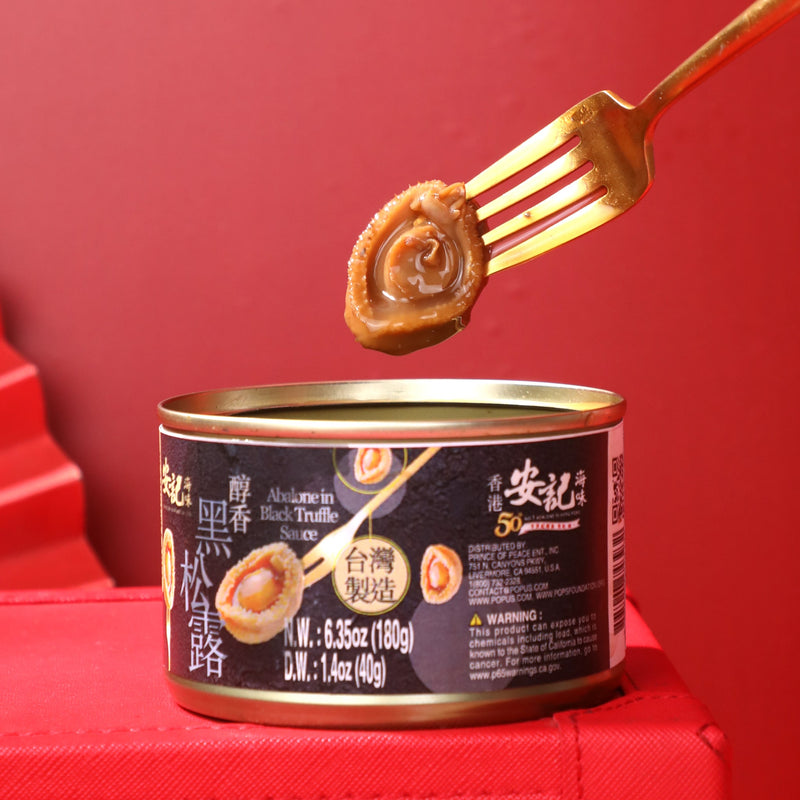 Abalones In Black Truffle Sauce on a red background.