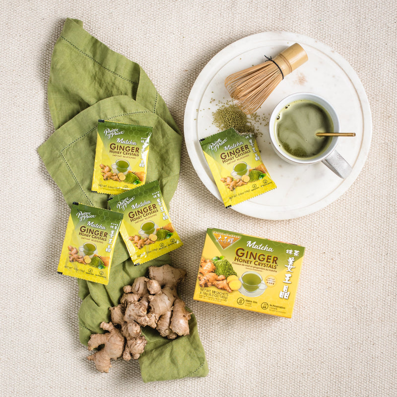A cup of Prince of Peace Ginger Honey Crystals Matcha with gingers and sachets on a tablecloth.