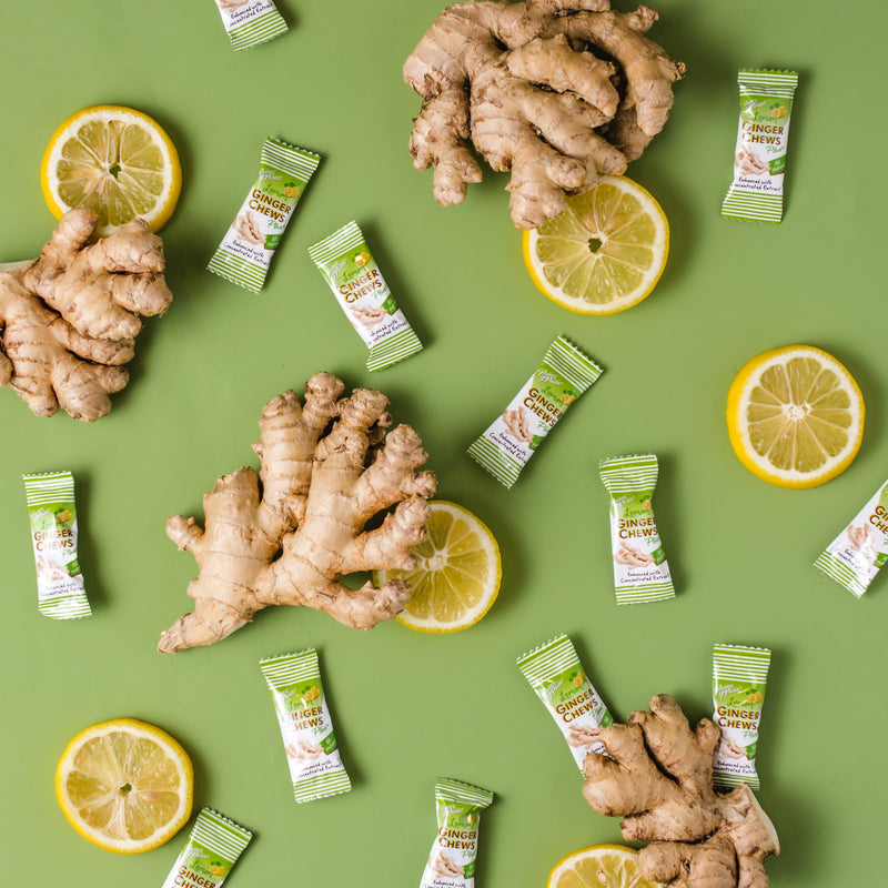 Pieces of Prince of Peace Ginger Chews Plus+, Lemon with lemon slices and ginger on a green background.