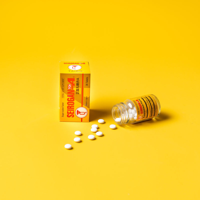 A box and a bottle Trumpet Brand Seirogan TOI-A with some pills aside on 
 yellow background. 