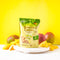 A package of Prince of Peace Ginger Candy (Chews) Mango with mango and mango slices on a white tray in front of a yellow background.
