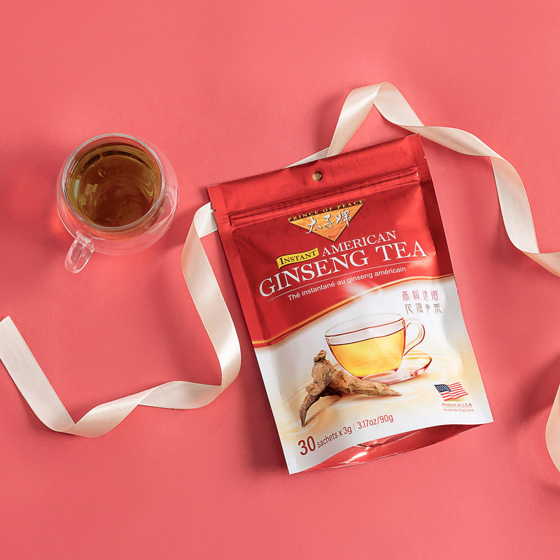 Prince of Peace American Ginseng Instant Tea with a cup of tea and a ribbon aside.