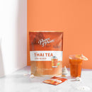 A glass of Prince of Peace 3-in-1 Instant Thai Tea with a small umbrella with a sachet, sea shell, and package.