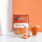 A glass of Prince of Peace 3-in-1 Instant Thai Tea with a small umbrella with a sachet, sea shell, and package.