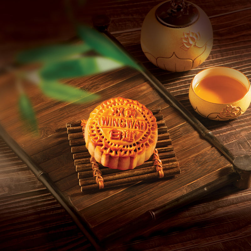 A Wing Wah 2 Yolks White Lotus Seed Paste Mooncake with a cup of tea