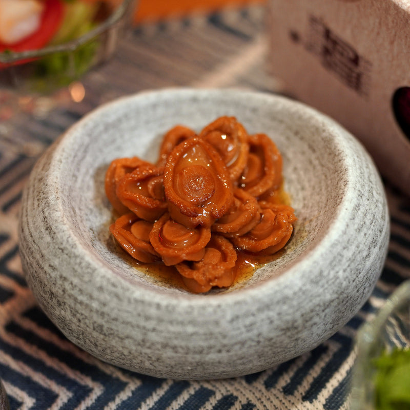 On Kee abalnoes in a ceramic plate on a tablecloth.