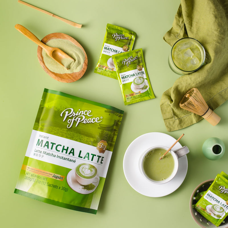 A glass of cold Prince of Peace 3-in-1 Instant Matcha Latte  and a cup of hot one with matcha powder and sachets aside.