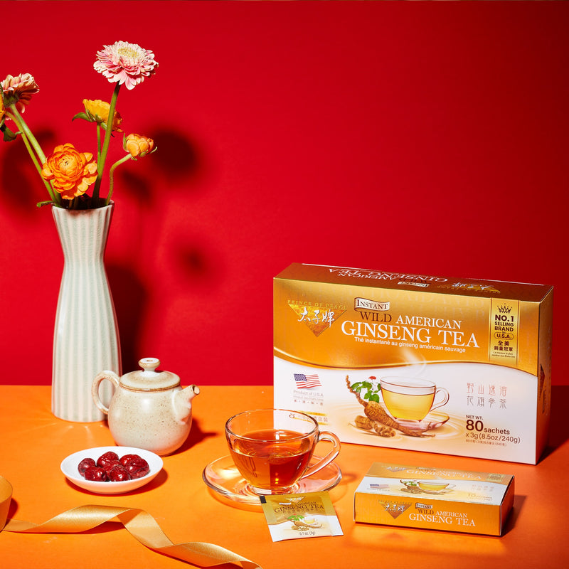 Prince of Peace Wild American Ginseng Instant Tea box and sachet with a cup of tea and a tea pot on the table.