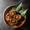 4 pieces of On Kee Braised Abalone on leaves in a wooden tray.